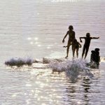 Photo of children diving off a lake raft in Maine