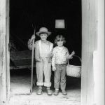 Photo of boy and girl standing in the doorway of a barn