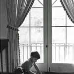 Photo of boy doing a jigsaw puzzle in front of windows