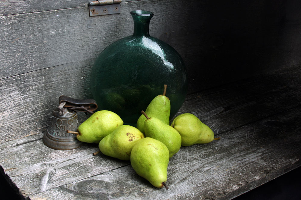 Photo of pears, antique handbell, green glass bottle